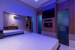马瑙斯Tucumã Motel的卧室配有白色的床和电视