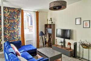 圣康坦Les Appartements de la Nef d'Or的客厅配有蓝色的沙发和电视