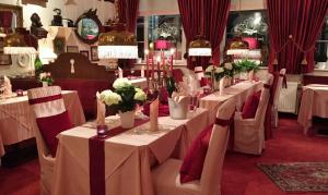 艾恩贝克Hotel Der Schwan的用餐室配有白色的桌椅和鲜花