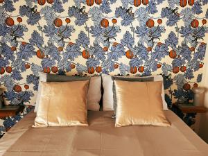 比萨San Ranieri Tiny Tower的墙上一张带两个枕头的床