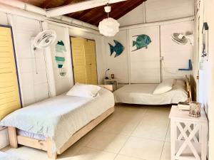 San OnofreCasita Caribe en reserva natural, playa privada, kayaks, wifi, aire acondicionado的配有2张床的白色墙壁和黄色门