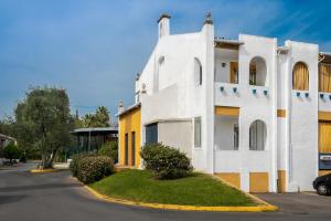巴伦西纳德拉孔塞普西翁Apartamento Aljarafe的白色的建筑,带有黄色的点缀,靠近街道