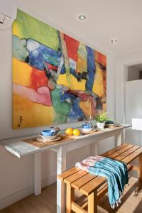 巴伦西纳德拉孔塞普西翁Apartamento Aljarafe的挂在墙上的画,有桌子和长凳