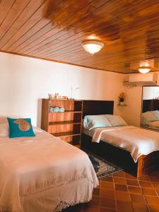 圣卡塔利娜岛科仪芭之家酒店的一间卧室设有两张床和木制天花板