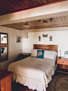 圣卡塔利娜岛科仪芭之家酒店的一间卧室配有一张大床和木制床头板