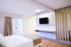 Erval VelhoHotel do Gringo的一间卧室配有一张床和一台平面电视
