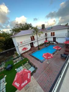 达累斯萨拉姆Hotel Totara的享有酒店高空的景致,设有游泳池和红伞