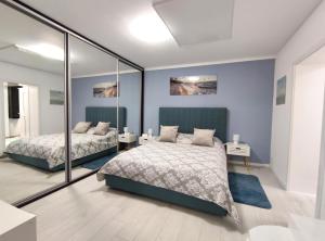 康斯坦察Studio'24的卧室设有两张床,配有蓝色的墙壁和镜子