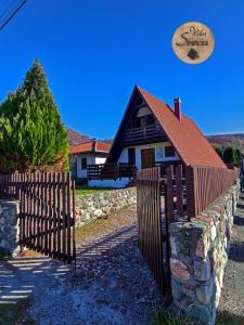 科拉欣Vila Sreća - Kolašin的天空中带围栏和飞盘的房子