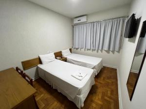 阿西斯圣罗莎酒店的客房设有两张床、一张桌子和一扇窗户。