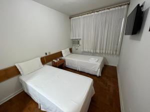 阿西斯圣罗莎酒店的小房间设有两张床和电视
