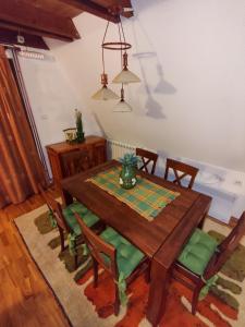 科拉欣Vila Sreća - Kolašin的一间带木桌和椅子的用餐室