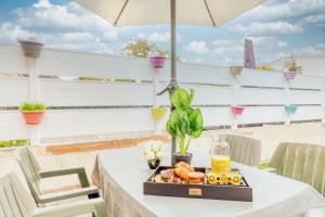 奥尔日河畔布雷蒂尼appartement tout équipé avec terrasse et parking privé的桌子上带雨伞的食品托盘