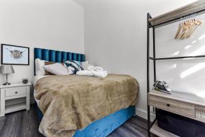 伦敦Comfy and Contemporary One Bedroom Flat的一间卧室配有一张蓝色床头板的床