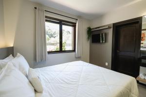 本图贡萨尔维斯Malbec Casa Hotel的卧室配有一张大白色床和窗户