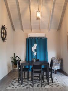 Saint GeorgeQuiet Country Living的一间带桌椅和蓝窗帘的用餐室