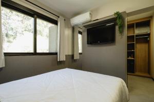 本图贡萨尔维斯Malbec Casa Hotel的卧室配有白色的床和电视