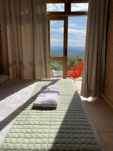 德尔菲诺波利斯Casa Erva Doce Pousada的窗户间里一张带毛巾的床