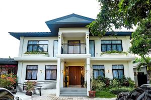 杜马格特UNWND Boutique Hotel Dumaguete的白色房子,前门打开