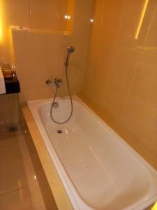 雅加达UNUMA HOTEL的浴室设有浴缸和淋浴。