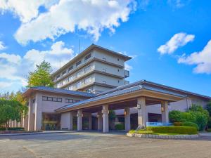 芦原市Yukai Resort Premium Seiunkaku的前面有停车位的大楼