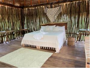 科巴Hotel Jungla y Estrellas的稻草小屋内一间卧室,配有一张床