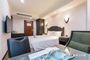 台北玩行旅大安分馆的酒店客房带一张床、一张桌子和椅子