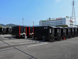 四国中央市HOTEL R9 The Yard Shikokuchuo的停在停车场的一排火车车厢