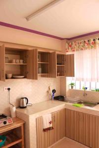 MeruCosy and spacious apartment in Meru的厨房配有木制橱柜和台面