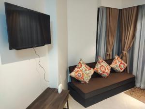 MaribagoTambuli Residence的客厅配有带枕头的沙发和电视