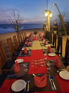 本托塔雅努斯天堂休憩住宿加早餐旅馆的沙滩上一张长桌,上面有红色的餐巾