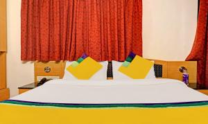 浦那Itsy By Treebo - Crown Inn的一间卧室配有带色彩缤纷枕头的床。