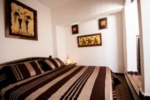 索维拉里亚德巴布索维拉摩洛哥传统庭院住宅的一间卧室配有一张床,墙上挂着一些图片