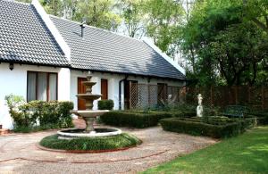 马加利斯堡布得玛施乡村山林小屋的一座花园,房子前面有一个喷泉