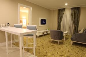 科贾埃利卢克索花园酒店的客厅配有白色的桌子和椅子