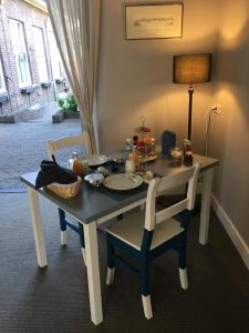 马斯特里赫特Guesthouse Thoez的一张桌子,两把椅子,一张桌子,上面有食物