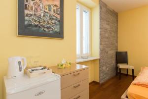 奥米沙利Villa Ajda - Orange room的卧室拥有黄色的墙壁,配有一张床和梳妆台
