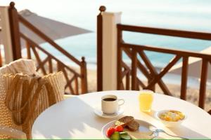 毕达哥利翁Potokaki Beachfront Hotel的餐桌,上面放着一盘食物和一杯橙汁