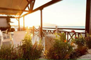 毕达哥利翁Potokaki Beachfront Hotel的庭院配有桌椅和植物