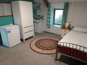 廷塔杰尔Dolphins Backpackers的一间小卧室,配有床、水槽和水槽