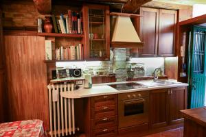 MombaroccioIl Poggio的厨房配有木制橱柜、水槽和散热器