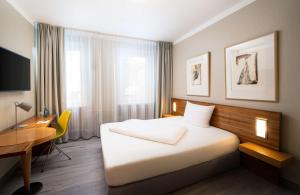 汉诺威elaya hotel hannover city的配有一张床和一张书桌的酒店客房