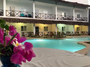 南威Kibanda Lodge and Beach Club的一座带游泳池和紫色鲜花的酒店