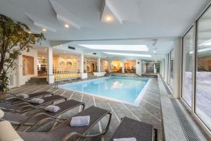 布鲁尼科费里耶微西齐健康酒店的一座酒店游泳池,四周摆放着躺椅