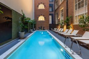 布里斯班阿迪娜布里斯班公寓酒店的一座配有桌椅的酒店游泳池