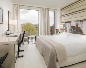 伦敦H11伦敦滑铁卢酒店的配有一张床、一张书桌和一扇窗户的酒店客房