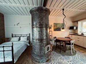 帕维洛斯塔Pāvilostas Šīfermāja的一间卧室配有一张床和一张带炉灶的木桌