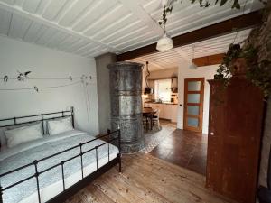 帕维洛斯塔Pāvilostas Šīfermāja的一间卧室配有一张床,铺有木地板