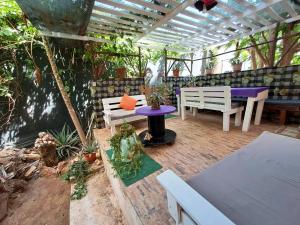 萨尔雷Apart-Hotel Ca Elsa的庭院配有桌子、紫色桌子和长凳