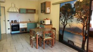 佩斯基耶拉德加达KINDLY ROBERTA centro storico Peschiera,lago relax的一间带桌子的厨房和一间带绘画的厨房